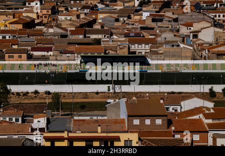 Luftaufnahme der kleinen Stadt, Consuegra, Castilla la Mancha, Spanien, mit Aktivitäten im Fußballfeld der Stadt Stockfoto