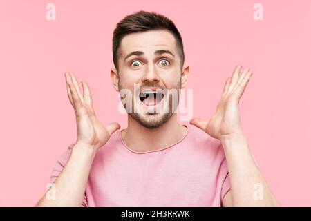 Nahaufnahme eines überraschten und staunenden Mannes mit erhobenen Armen Stockfoto