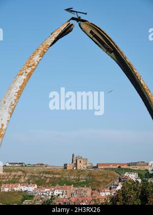 Der Whalebone Arch in Whitby in North Yorkshire umrahmt die weit entfernte gotische Kirche St. Mary im Hintergrund England UK Stockfoto