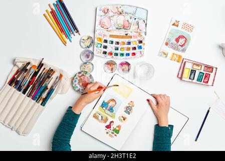 Illustrator Woman malt einige Skizzen mit Aquarellen Stockfoto