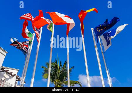 Flaggen vieler Länder wie argentinien spanien usa kanada italien und europa mit blauem Himmel und Palmen in Playa del Carmen Mexiko. Stockfoto