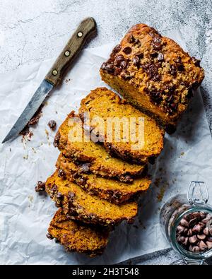 Aufschnitt-Kürbis-Bananenbrotkuchen mit Schokoladenchips und einem Messer Stockfoto