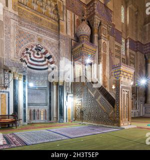 Bunt dekorierte Marmorwand mit gravierter Mihrab - Nische - und hölzerner Minbar - Plattform - an der öffentlichen historischen Al Rifaii Moschee, aka Königliche Moschee, Alt-Kairo, Ägypten Stockfoto