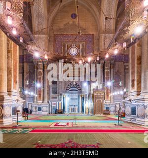 Innenraum der öffentlichen historischen Al Rifaii Moschee, auch bekannt als Königliche Moschee, mit bunt dekorierten gravierten Mihrab und hölzernen Minbar, Kairo, Ägypten Stockfoto