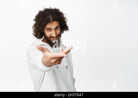 Leidenschaftlicher, gutaussehender hispanischer Mann, romantisch, strecken seine Hand aus, laden zum Tanz ein und geben dir etwas in seiner Handfläche, weißer Hintergrund Stockfoto