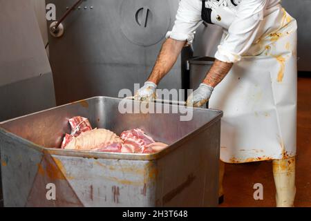 Arbeiter, der Maschinen zur Herstellung von Würsten in einer Fleischverarbeitungsanlage betreibt Stockfoto