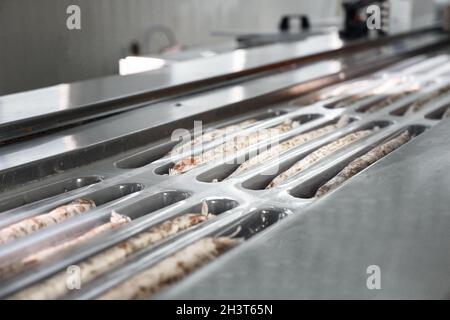 Würstchen. Verpackungslinie von Würsten. Industrielle Herstellung von Wurstwaren. Stockfoto