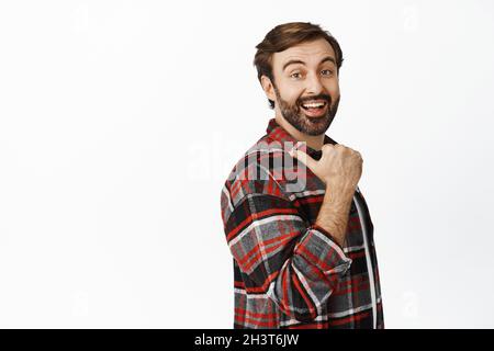 Ein enthusiastisch lächelnder Mann zeigt nach links, zeigt großes Promo-Angebot, Verkauf oder Rabatt im Geschäft und steht auf weißem Hintergrund Stockfoto