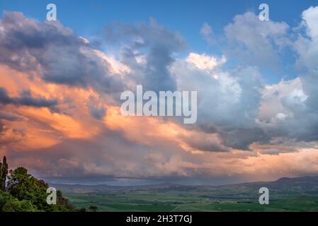 Der Sonnenuntergang erleuchtet Wolken über dem Ackerland in der Nähe von Pienza in der Toskana Stockfoto