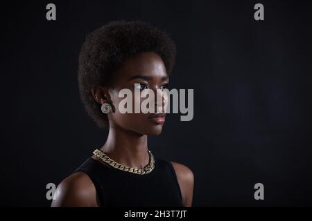 Nahaufnahme Porträt einer afroamerikanischen Frau mit Afro-Frisur auf schwarzem Studiohintergrund Stockfoto