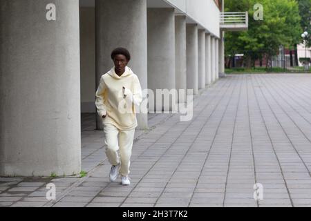 Afroamerikanische Läuferin Frau im Hoodie beim Joggen im Freien Stockfoto