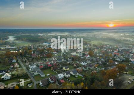 Eine kleine Provinzstadt. Eine Rauchwolke hängt über den Gebäuden, Smog aus den Schornsteinen. Das Foto wurde mit einer Drohne aufgenommen. Stockfoto