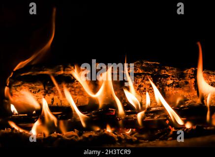 Feuerflammen und heiße Kohlen von verbranntem Holz im Kamin Stockfoto