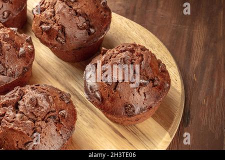 Ein Nahaufnahme-Foto von Schokoladen-Muffins auf einem dunklen rustikalen Holzhintergrund Stockfoto
