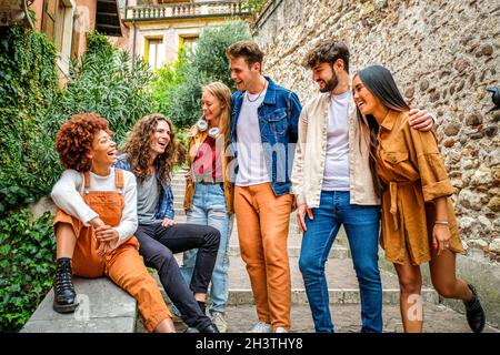 Multiethnische Gruppe von jungen Menschen reden und Spaß haben auf den Treppen in den Straßen der Stadt und - Urban und Freundschaft Konzept Stockfoto