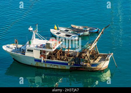 Alte Fischtrawler und drei hölzerne Ruderboote, die im Hafen von Lerici, Ferienort an der Küste des Golfs von La Spezia, Italien, Europa, vertäut sind. Stockfoto