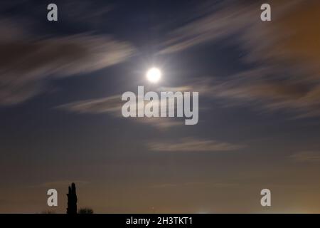 Nachtfoto und Vollmond am Himmel und Wolken vor dem Mond über dem Stadtlicht von Bursa Stockfoto