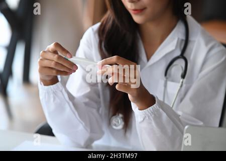 Kurzer Schuss charmante Ärztin trägt Uniform in der medizinischen Klinik arbeiten. Stockfoto