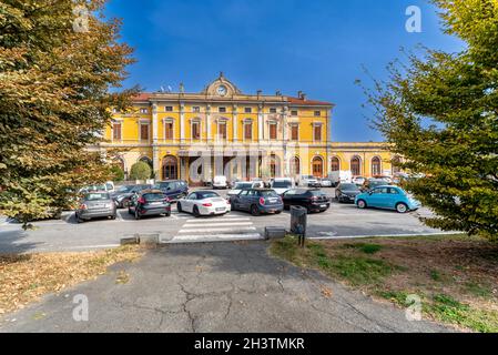 Saluzzo, Cuneo, Italien - 19. Oktober 2021: Alter Bahnhof im corso Roma mit herbstlichen Bäumen Stockfoto