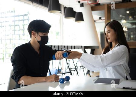 Junger asiatischer Mann, der die Behandlung mit einem Physiotherapeuten in einer medizinischen Klinik macht. Stockfoto