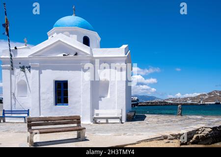 Kirche mit blauer Kuppel in Chora Stadt Mykonos Insel, Kykladen. Griechenland. Weiße Kapelle am Meer auf klarem blauen Himmel Hintergrund. Stockfoto