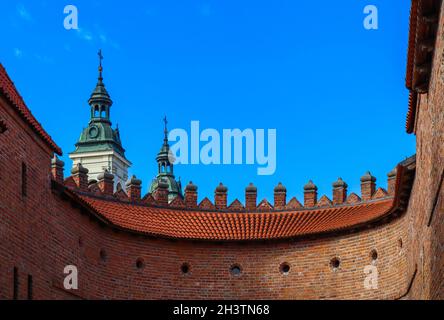 Zwei Türme mit spiers und roten Backsteinmauern des barbican Warschau, Polen Stockfoto