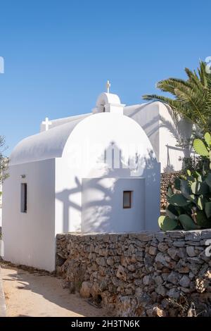 Folegandros Insel, kleine Kirche in Chora Stadt. Griechenland, Kykladen. Traditionelle Kapelle, weiß getünchte Wände und Kuppel, blauer Himmel im Hintergrund. Stockfoto