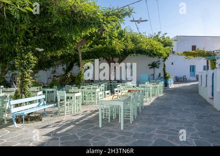 Griechenland, Insel Folegandros. Traditionelle Café-Bar und Taverne im Freien. Blaue leere Tische und Stühle, Chora-Stadtplatz. Kykladen. Sommerferien destin Stockfoto