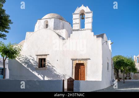 Folegandros Insel, Alte Kirche am Chora Stadtplatz. Griechenland, Kykladen. Agios Antonios-Kapelle, weiß getünchte Wände, Kuppel und Glockenturm, blauer Himmel hinten Stockfoto