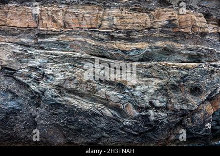 Grau braun leere alte raue felsige Wand für Hintergrund, Textur. Äußere Grunge Steinklippe des Tamelos Kaps auf der Insel Tzia, Griechenland. Vintage leerer Riss Stockfoto