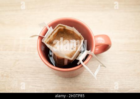 Kaffee tropft in die Tasse. Alternativer Brühkaffee in Papierfiltertüten. Stockfoto