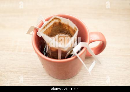 Kaffee tropft in die Tasse. Alternativer Brühkaffee in Papierfiltertüten. Stockfoto