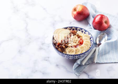 Haferflocken mit karamellisierten Äpfeln mit Zimt, Banane und geriebenen Erdbeeren Stockfoto