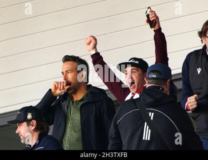 Die Besitzer von Wrexham, Ryan Reynolds (links) und Rob McElhenney (Mitte), feiern das erste Tor ihres Spielers, das Harry Lennon während des Spiels der Vanarama National League auf dem Pferderennbahn-Gelände in Wrexham erzielte. Bilddatum: Samstag, 30. Oktober 2021. Stockfoto