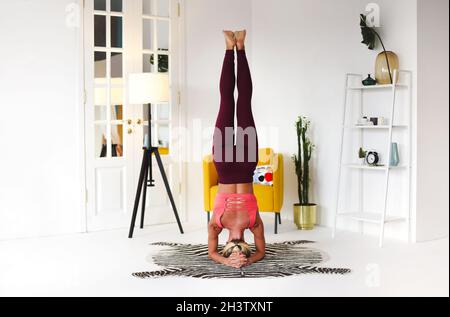 Schlanke Frau tut Balancing Handstand Asana Stockfoto