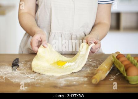 Crop Frau bereitet Teig am Tisch zu Hause Stockfoto