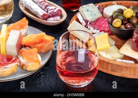 Rosenwein mit Wurstwaren, Käse und Lachs-Sandwiches. Spanische Tapas Stockfoto