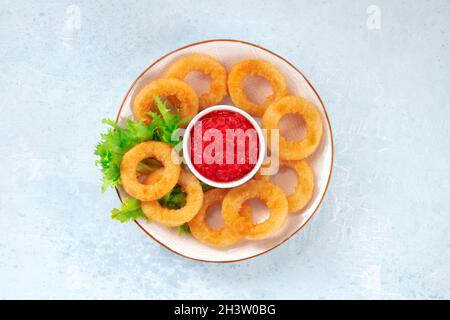 Calamari-Ringe mit grünem Salat. Frittierte Tintenfischringe Stockfoto