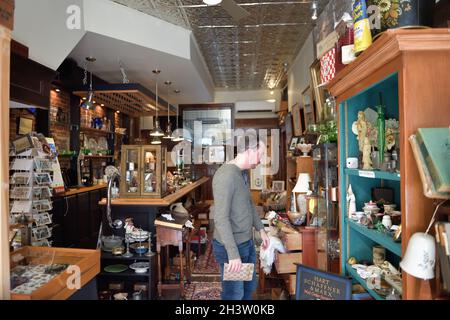 Gardiner, Maine, USA. Mann, der in einem der zahlreichen Geschäfte entlang der angenehmen und ordentlichen Hauptstraße in der kleinen Maine-Gemeinde Gardiner stöbert. Stockfoto