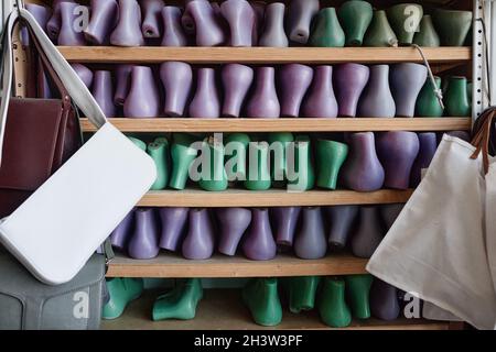 Bild von Holzschnur für Kinder- und Herrenschuhe in einer Reihe auf den Regalen in der Werkstatt Stockfoto