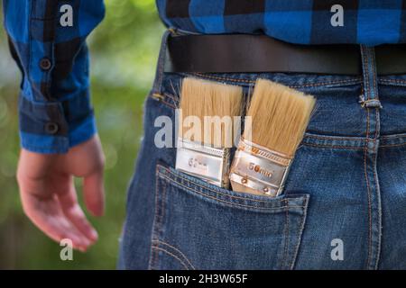 Heimwerker: Rückansicht eines jungen Mannes mit Pinsel in der Tasche Stockfoto