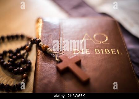 Heilige bibel und Rosenkranz: Christliche bibel und Rosenkranz auf einem Holztisch Stockfoto