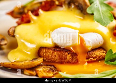 Nahaufnahme von Eiern Benedict mit Sauce Hollandaise und flüssigem Eigelb Stockfoto