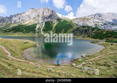 Schöne und idyllische Berglandschaft: Bergkette, See mit klarem Wasser und blau bewölktem Himmel Stockfoto