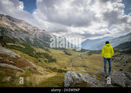 Mann in Sportbekleidung und mit Rucksack genießt die Aussicht in die Berge Stockfoto