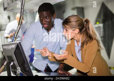 Mann und Frau in Angst auf der Suche nach einer Lösung auf dem Computer im Quest-Zimmer Stockfoto