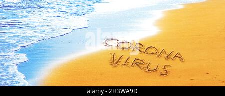 Corona-Virus im Urlaub in den Sand geschrieben Stockfoto