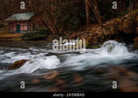 Abgelegene Hütte in Winterlandschaft. Wasserstrahl. Aufnahme mit langer Belichtung. Stockfoto