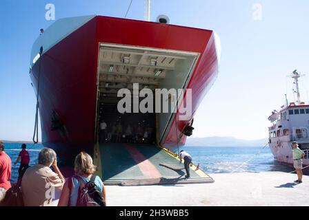 Agistri Insel Griechenland dramatische Ansicht der lokalen Fähre, angedockt am Hafen Passagiere warten auf Aussteigen Stockfoto