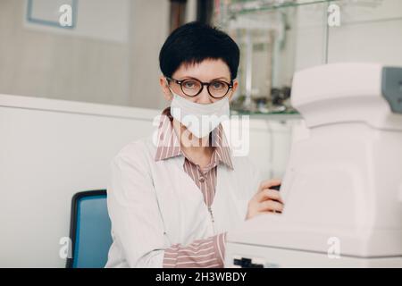 Professionelle Frau Arzt mit Augentests elektronische digitale moderne Geräte Überprüfung Vision Stockfoto